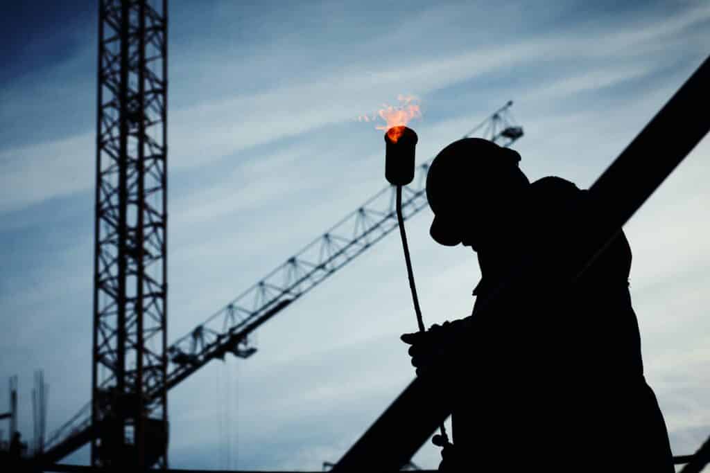 Silhouette of a man working hard at a construction site